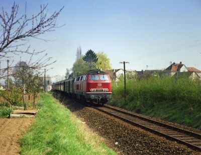 Aus dem längst zum Haltepunkt zurückgestuften Bahnhof Weckesheim beschleunigte am 24.04.1978 die 216 115-6 entlang der vorfrühlingshaften Gärten in Richtung Friedberg (Hess).
